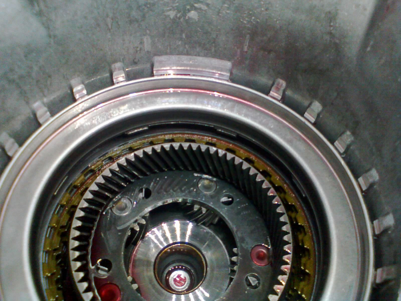 Return spring goes in first, then the piston in the housing. Another snap-ring must go atop here to lock the piston housing against the case.